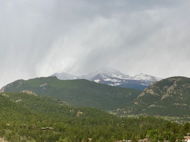 Rain descending on snow capped mountains outside of Estes Park, CO