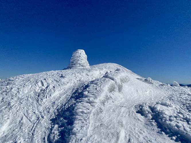 Snow-covered trail rock cairn near Boundary Peak's summit