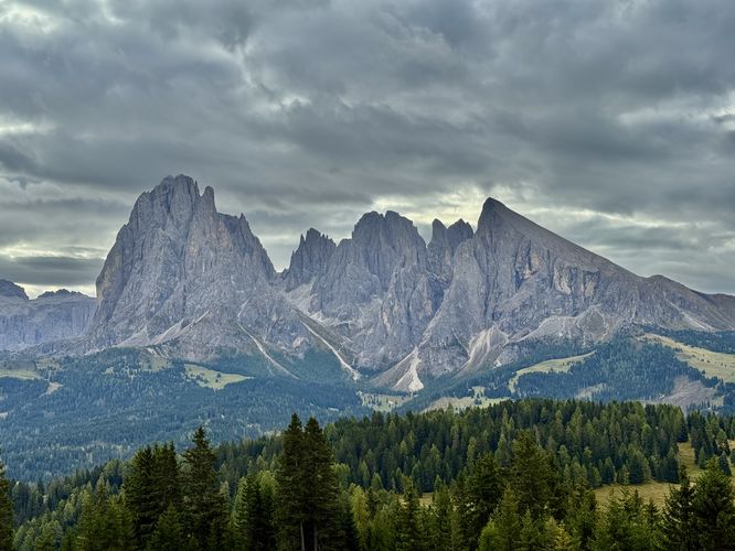 A cloudy, moody morning view of Alpe di Siusi and the alpine mountains that tower over the plateau