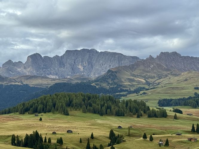 Alpine ridges stand tall above the high-elevation plateau of Alpe di Siusi, located south of the meadows