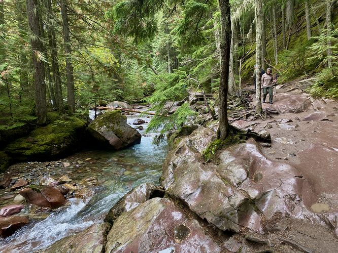 Hikers headed down the trail alongside Avalanche Creek and its beautiful water