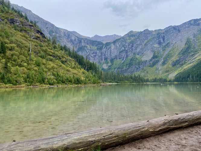 View of Avalanche Lake's glassy water with surrounding alpine mountains