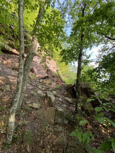 Path leads between the ledge and fallen boulders