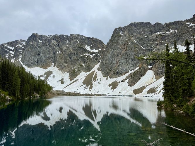 Alpine mountains sit above the dark blue waters of Blue Lake