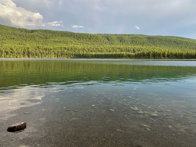View of Bowman Lake's clear water and neighboring hills