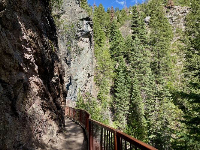 Trail skirts under a steep cliff to enter Box Canyon
