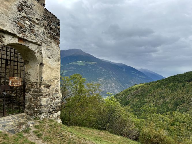 View of the Italian Alps of South Tyrol next to the gated entrance to Castel Montani di Sopra