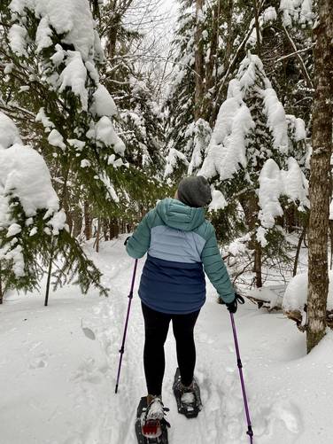 Snowshoeing through snow-covered trees along the Pitchoff Mountain Trail