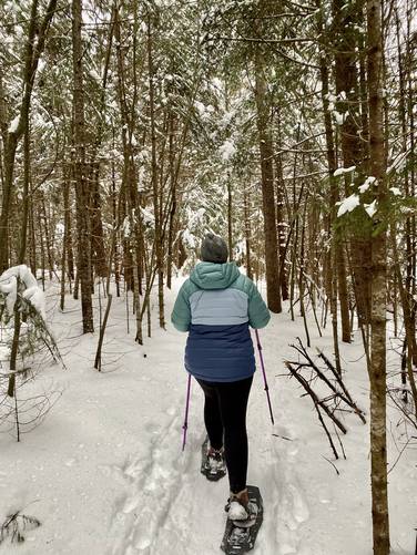 Snowshoeing through snow-covered trees along the Pitchoff Mountain Trail