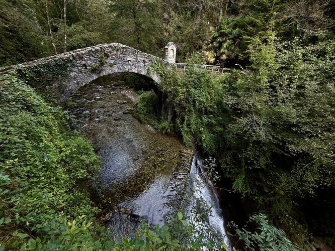 Stone footbridge sits above Cascata di Tobi