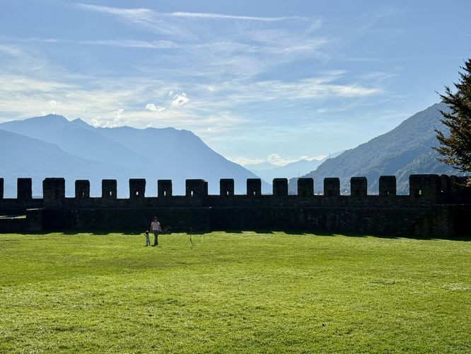 Alps surround Castle Grande in the background as seen from the grassy courtyard