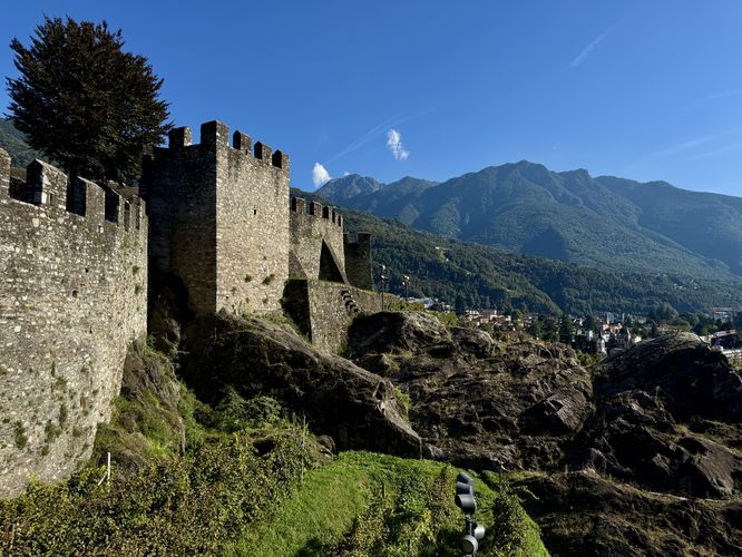 A view of Castel Grande's fortified walls with surrounding mountains in the background