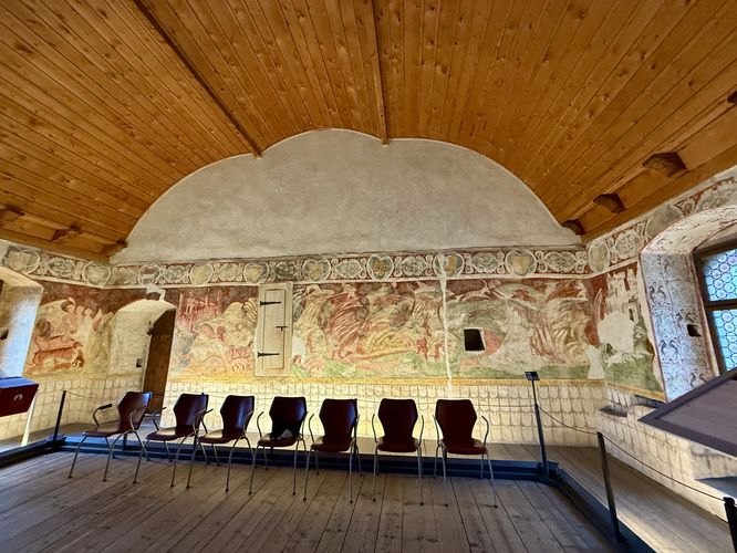 Storybook-like frescoes and a ship hull ceiling in Castel Roncolo's West Palace