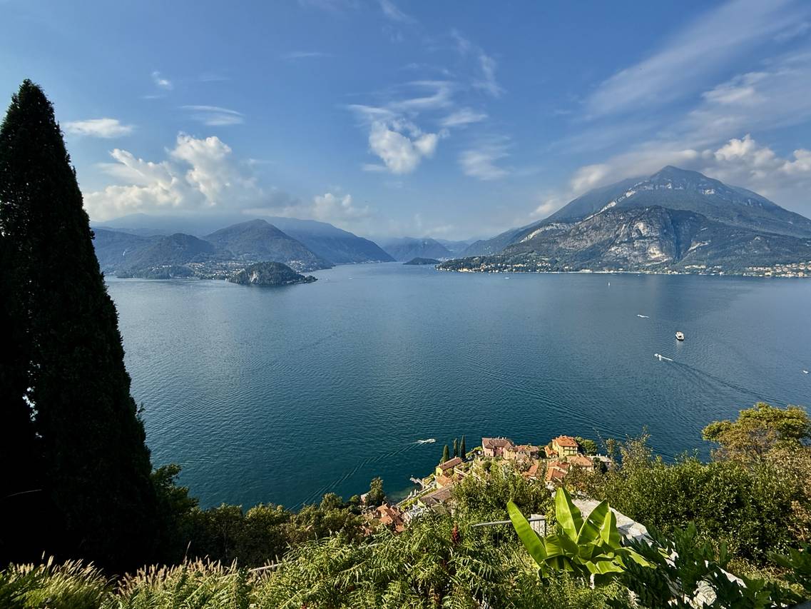 A scenic view of boats sailing on the deep blue waters of Lake Como, with mountains and charming villages in the background.