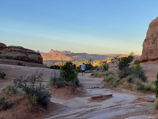 Hiking out from Delicate Arch with views of distant mountains