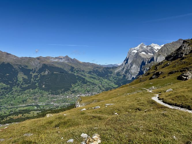 Eiger Trail as it winds through open meadows with panoramic vistas of Grindelwald, Switzerland