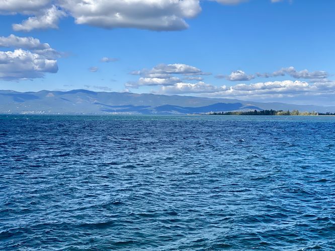 Deep blue water of Flathead Lake with mountains in the distance