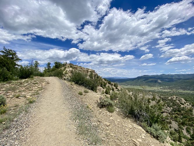 Trail begins to follow steep cliffs before the ridge continues