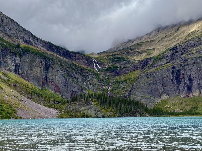 Turquoise waters of Grinnell Lake and view of 960-foot tall Grinnell Falls