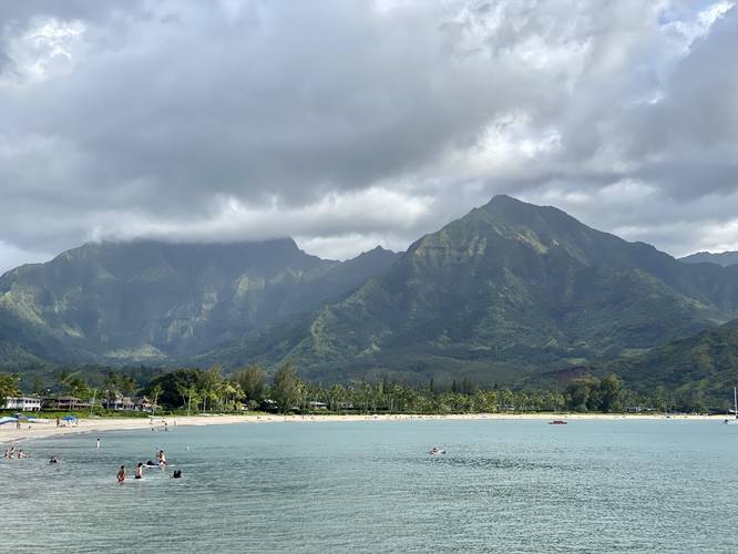 View of Hanalei Bay, docked boats, and surrounding mountains with a 2,800-foot waterfall cascading