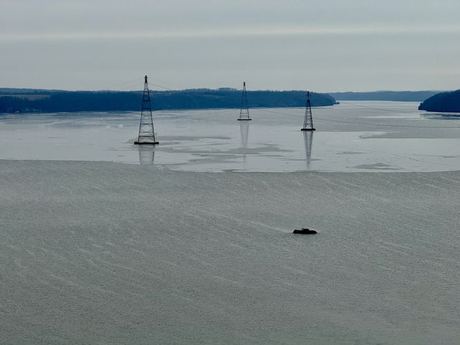 Electrical pylons stand in the river