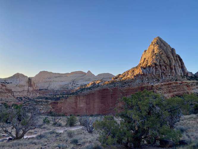Sunrise casts light upon the rock cliffs and reefs at Capitol Reef National Park