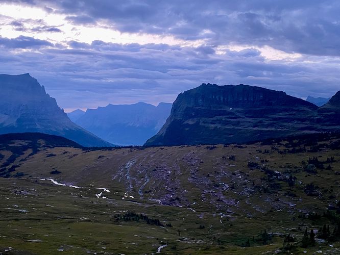 Sunrise with cloudy skies with views of Logan Pass from the trail