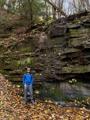 Sam Monks standing at the seasonal waterfall in Horn's Quarry