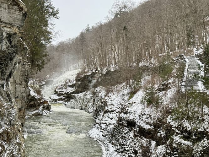 Frozen stairs lead up the trail with frozen spray from Lower Falls on the left-hand side