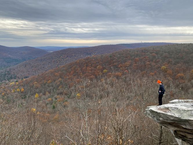 Sam Monks stands on the north cliffs of Kellogg Mountain's Overlook
