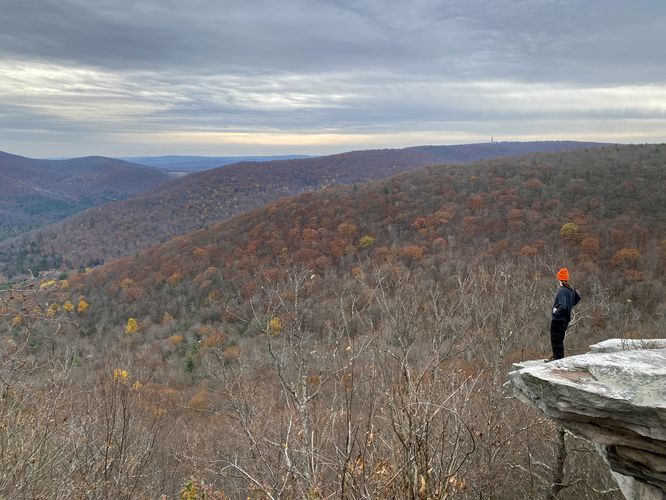 Sam Monks stands on the north cliffs of Kellogg Mountain's Overlook