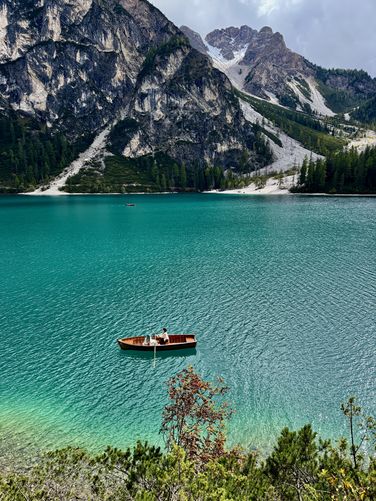 Blue-haired rowboater sits in the turquoise waters of Lago di Braies