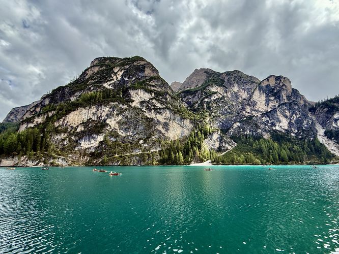 Row boats sit under towering alpine peaks of the Dolomites in Lago di Braies