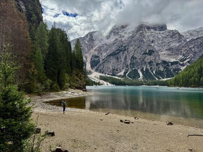 Hiker stands along the shore of Lago di Braies
