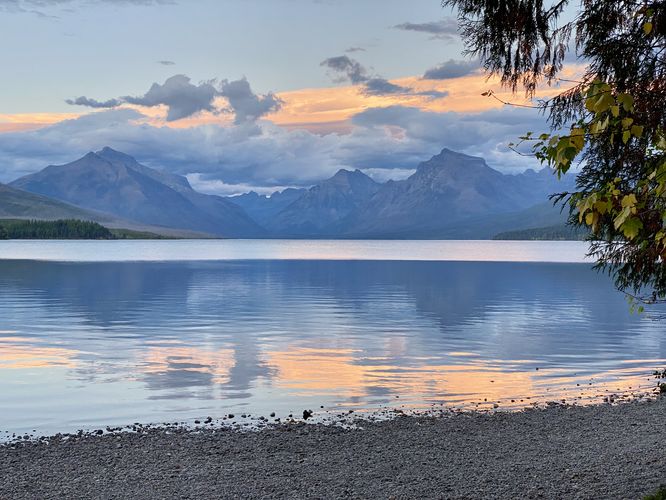 Alpine mountains stand over Lake McDonald at sunset