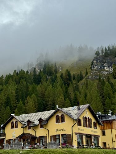 View of Pizzeria Edelweiss with a cloudy Alps backdrop