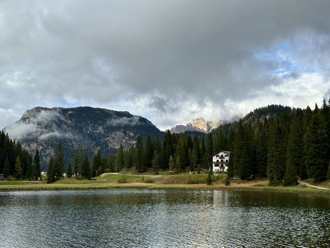 Alpine peaks sit in the clouds with a view of Lago di Misurina and Hotel Miralago