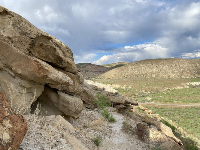 Trail skirts around a steep slope with small rock caves