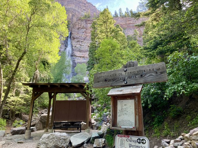 Lower Cascade Falls trail sign with view of waterfall