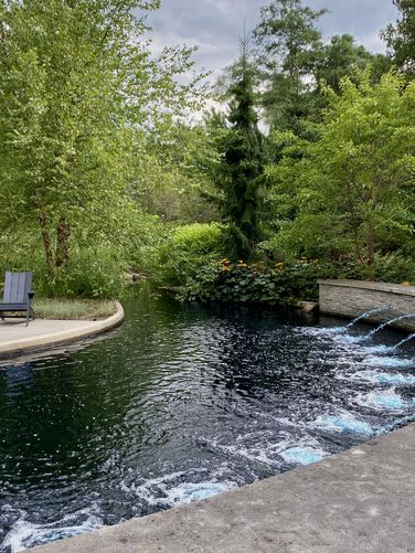 Water spouts feed the reflection pool with blue-dyed water