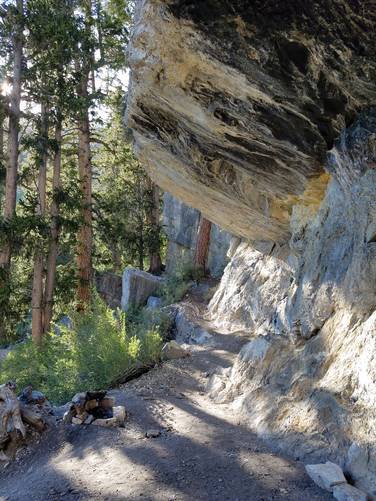 Trail follows under overhanging rock