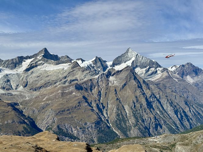 Helicopter flies into Zermatt with Alps in the background