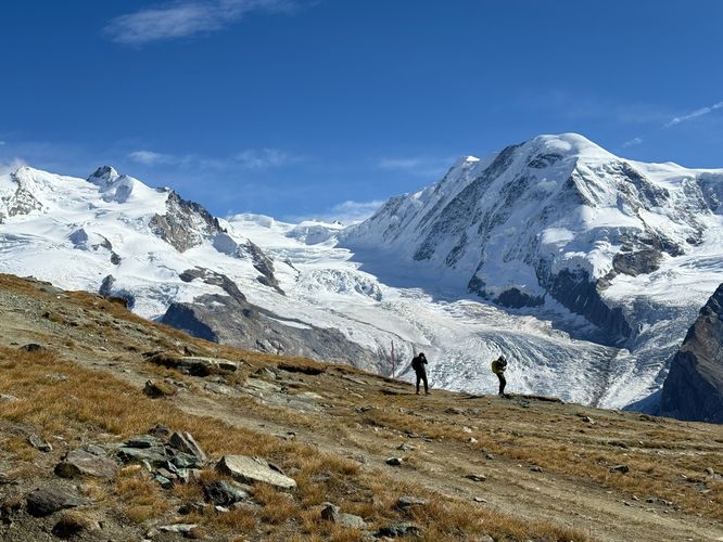 Hikers traversing Gorner Ridge with the Monte Rosa massif in the background