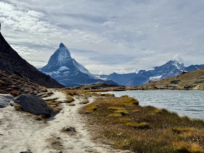 The iconic Matterhorn sits on the horizon with the glimmering waters of the alpine lake Riffelsee in Zermatt, Switzerland.