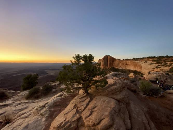 Sun is rising at Mesa Arch -- notice the hordes of people down below