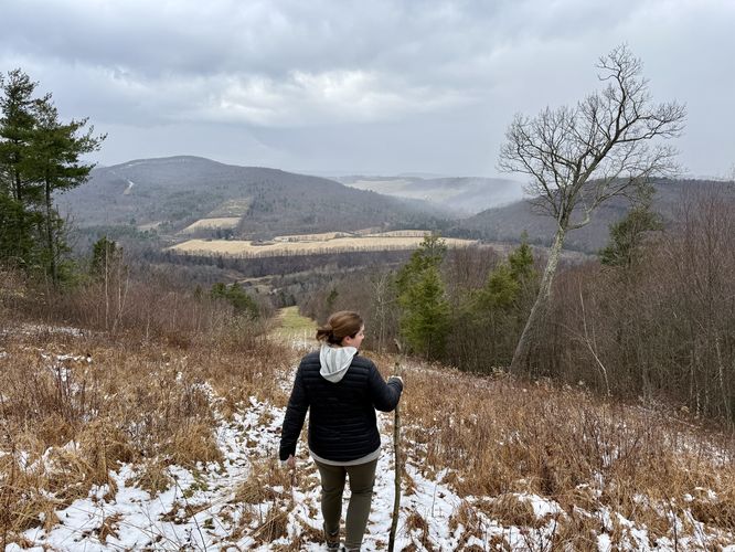 Curtain of snow covers hills in the distance as we hiked down the pipeline