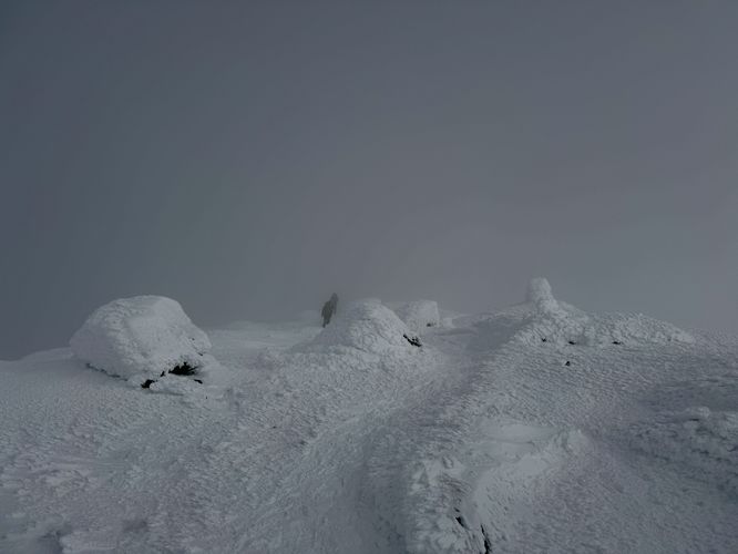 Cloud-covered, snow-drifted, frozen Mt Marcy summit