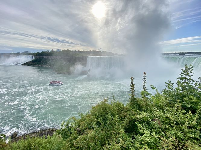 Boat approaches the base of Horseshoe Falls within Niagara Gorge, American Falls (left)