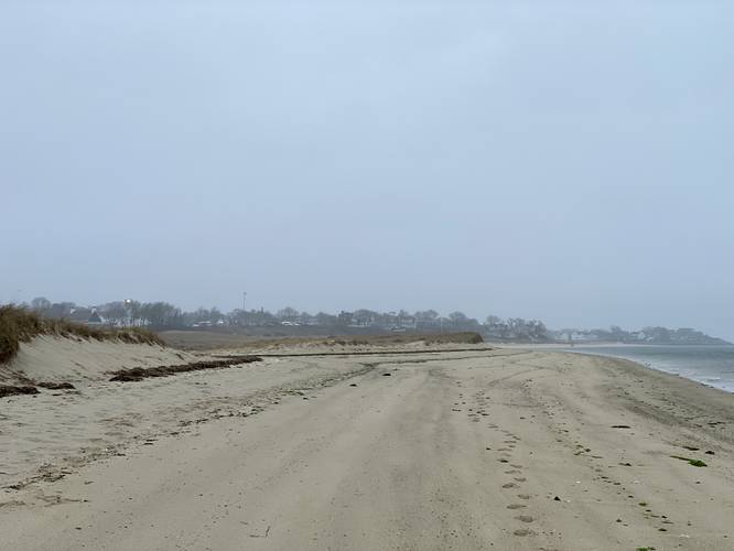 Foggy beach view with Chatham Lighthouse shining