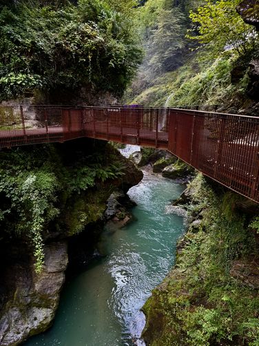 Turquoise waters flow under the suspended bridges at Orrido di Bellano